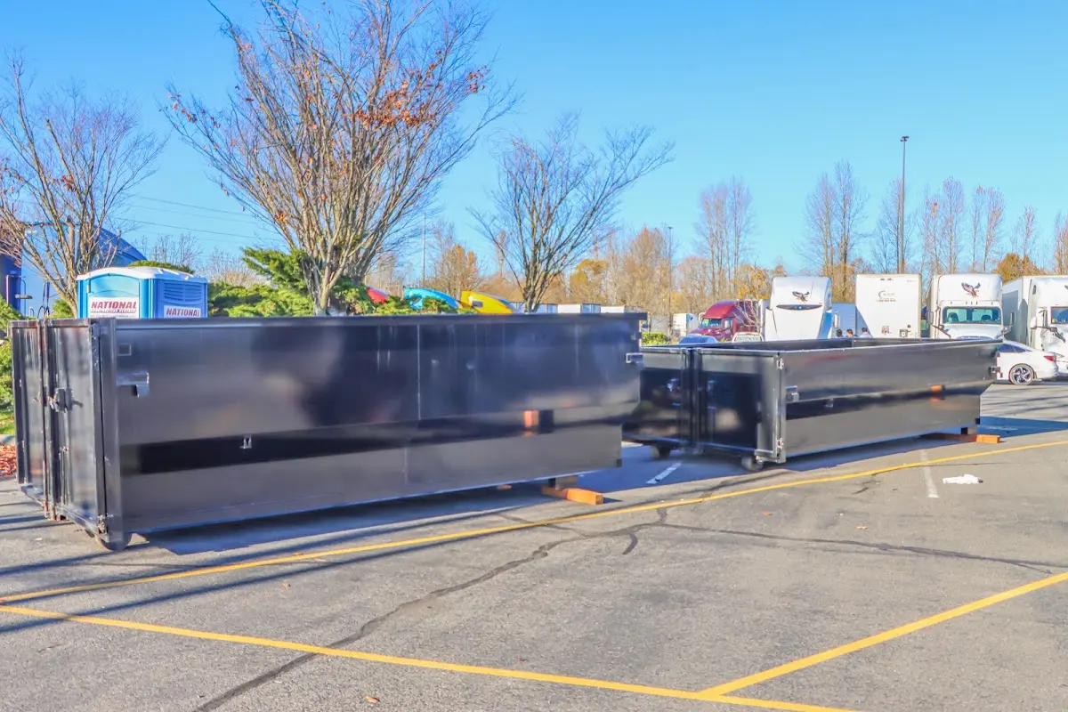 Professional dumpster rental service with roll-off container on residential driveway in Rowley